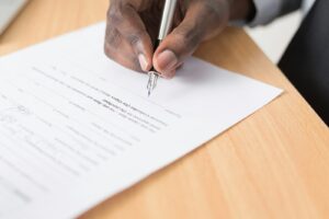 personne écrivant sur du papier blanc